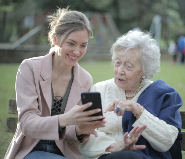 Datter og bedstemor kigger på mobilen sammen