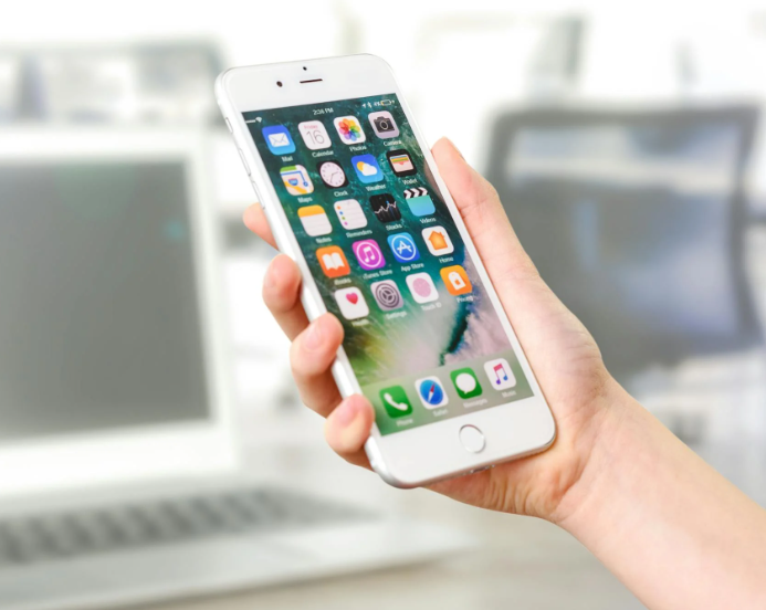 En hånd holder en hvid iPhone - personen har Lebara abonnement