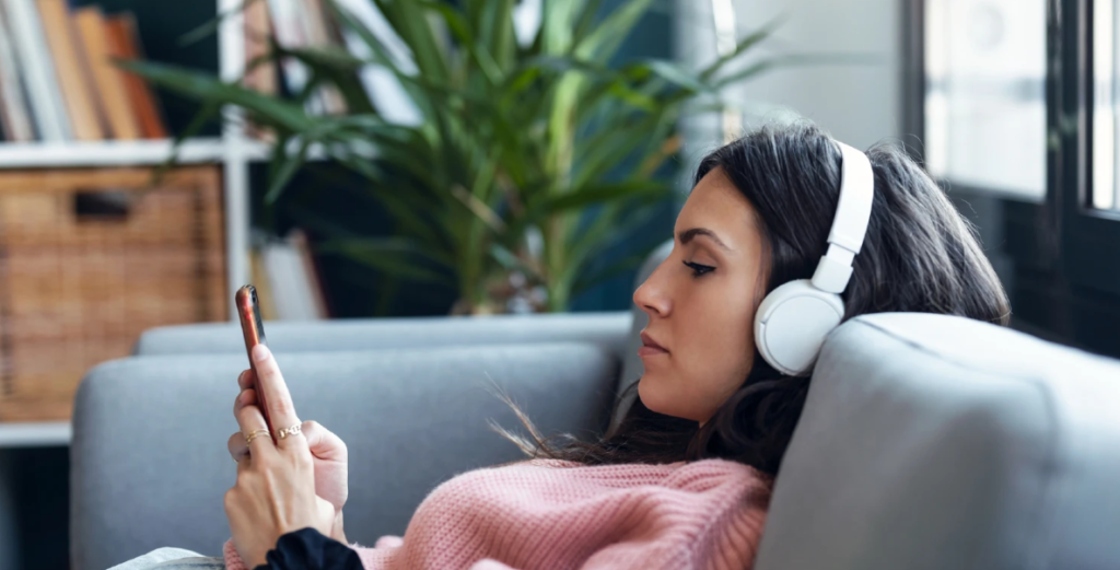 Kvinde med hovedtelefoner - lytter til lydbog