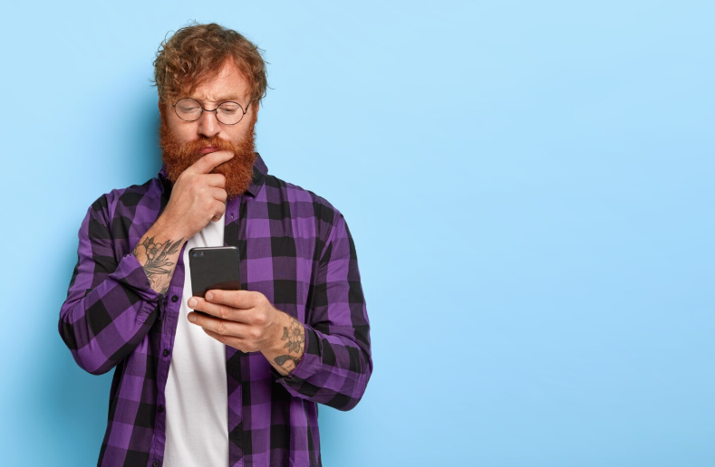 Mand står og tænker over mobilabonnement er dyrt